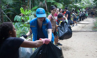 Depois de todo o lixo ser coletado, uma cadeia humana se formou para levar os sacos para a reciclagem. , by © ACNUR/Cesar Nogueira